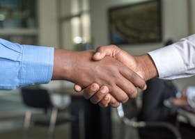 Close-up of two men's handshake symbolizing agreement in an office.